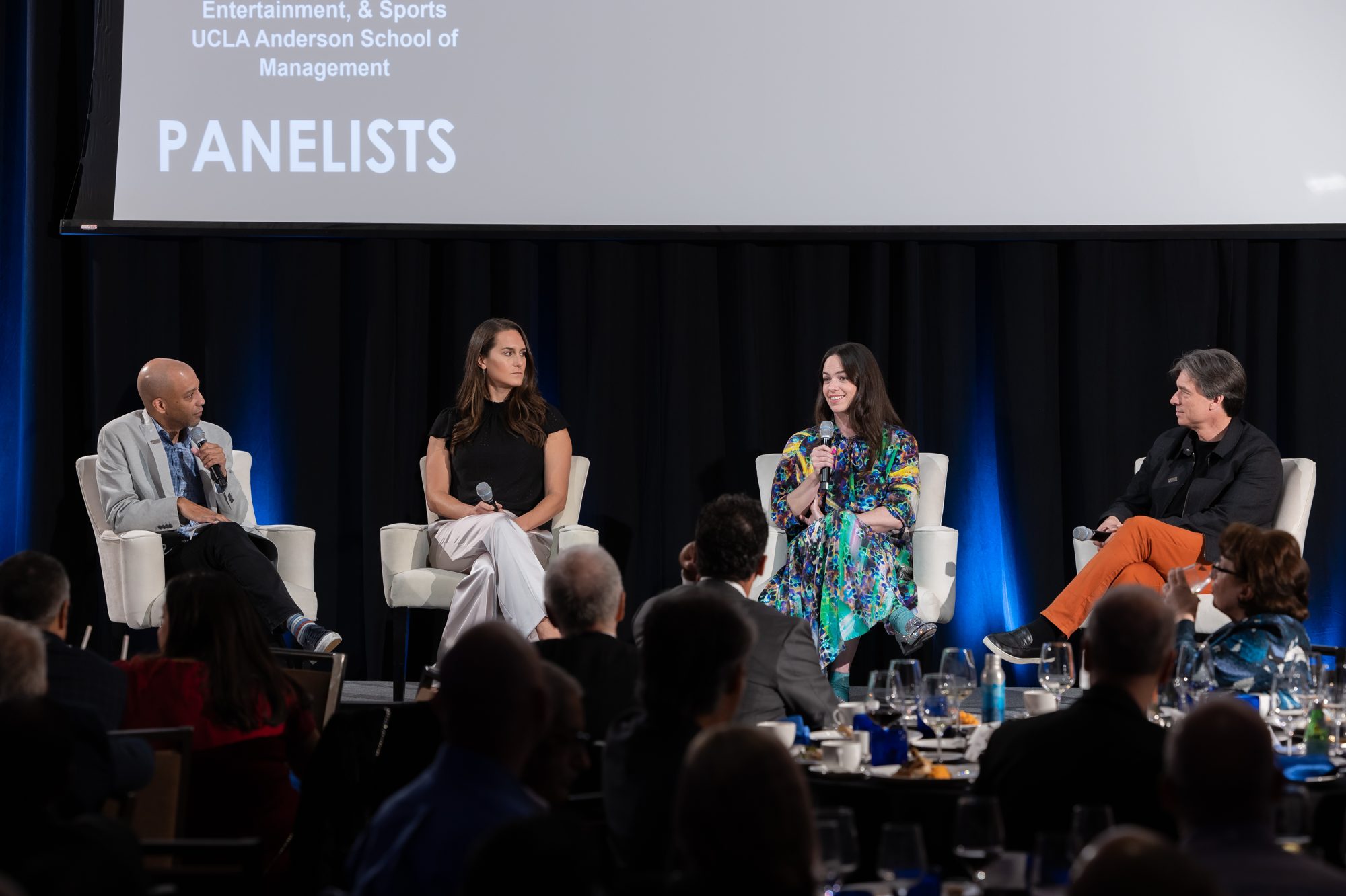 A panel discussion on stage at the Innovate@UCLA Executive Leadership Awards, with dinner guests in the foreground