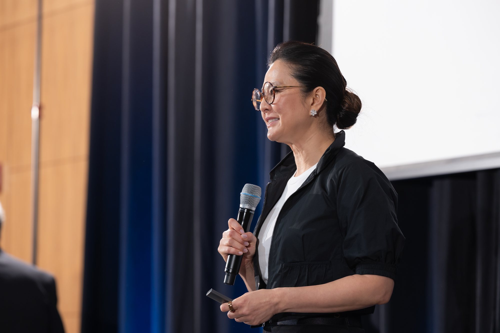 A speaker holding a microphone on stage at the Innovate@UCLA awards dinner